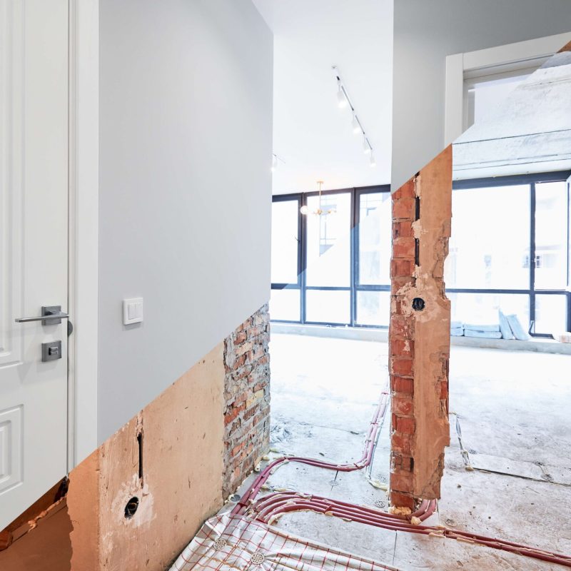 Salon et chambre avec de grandes fenêtres et portes, avant et après rénovation. Ancien appartement avant travaux et nouvel appartement rénové avec parquet et mobilier.