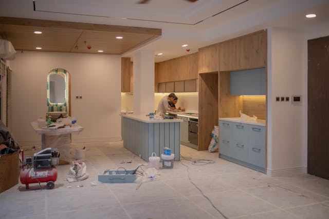 une cuisine en bois en pleine rénovation, deux artisans au fond, rénovation cuisine