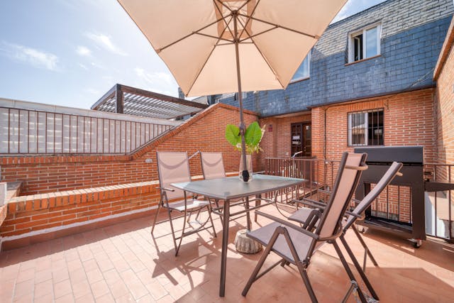 une table et des chaises sous un parasols sur un toit terrasse, toiture terrasse étanchéité