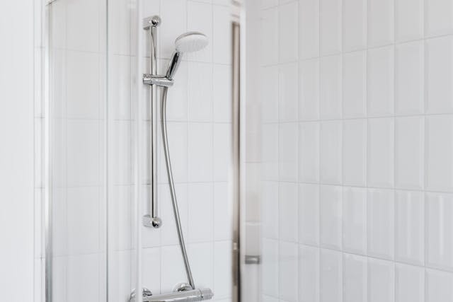 une colonne de douche sur carelage blanc, douche remplacement baignoire