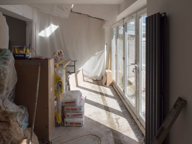 une pièce en blanc avec baie vitrée en pleins travaux de rénovation, rénovation plus-value immobilière