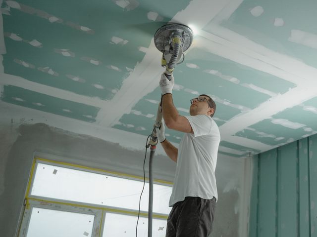 un artisant qui ponçe un plafond, artisan faux plafond